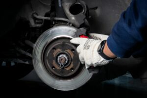 A professional brake mechanic inspecting a car’s braking system to ensure optimal safety and performance.